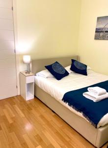 sypialnia z 2 łóżkami i niebieskimi poduszkami w obiekcie Luxury Four-Room Apartment in Monza Centro - 2 min walk to Train Station w mieście Monza