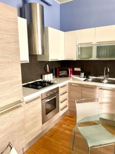 a kitchen with white cabinets and a glass table at Luxury Four-Room Apartment in Monza Centro - 2 min walk to Train Station in Monza