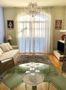 a living room with a glass table and a chandelier at Luxury Four-Room Apartment in Monza Centro - 2 min walk to Train Station in Monza