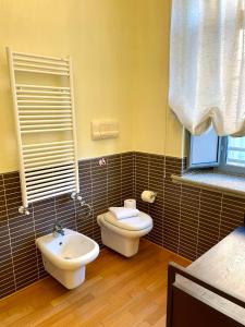 La salle de bains est pourvue de toilettes et d'un lavabo. dans l'établissement Luxury Four-Room Apartment in Monza Centro - 2 min walk to Train Station, à Monza
