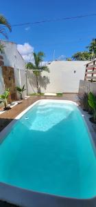 a large blue swimming pool in a yard at Loft completo com area de lazer piscina e churrsqueira in Natal