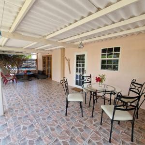a patio with a table and chairs on a brick floor at Nos Soño Stay and Dive in Westpunt