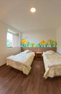 two beds in a room with a painting on the wall at Casa Boutique QX- Pachacamac in Pachacamac