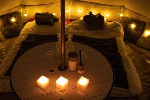 a table in a tent with candles and two beds at Stockholm Archipelago Retreat in Ingmarsö
