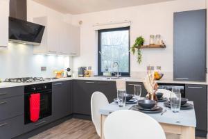 una cocina con electrodomésticos en blanco y negro y una mesa en Sleek Urban Living with Bicocca Stays, en Aberdeen