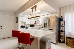 a kitchen with a refrigerator and red chairs in it at Perfect Beach Escape 1BD/1Bath Close to Everything in Fort Lauderdale