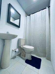 y baño con aseo, lavabo y espejo. en Posada Jimmy S House, en San Andrés