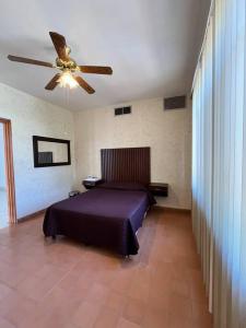 Schlafzimmer mit einem Bett und einem Deckenventilator in der Unterkunft Bed Bed Rooms in Torreón