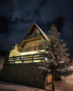 una casa con un árbol de Navidad delante de ella en VillaRostovo en Bugojno