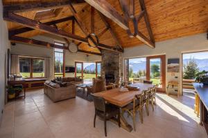 a large living room with a wooden table and chairs at Lake Hawea View in Albert Town