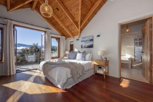 a bedroom with a large bed and a large window at Lake Hawea View in Albert Town