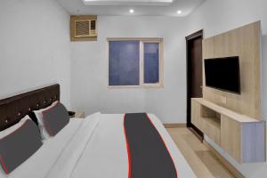um quarto com uma cama e uma televisão de ecrã plano em Collection O Babil Palace em Gurgaon