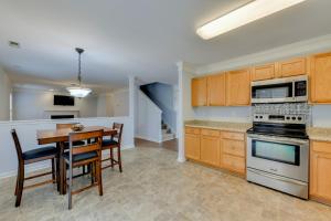 a kitchen with wooden cabinets and a table and chairs at Charlotte Home about 11 Mi to Downtown! in Charlotte