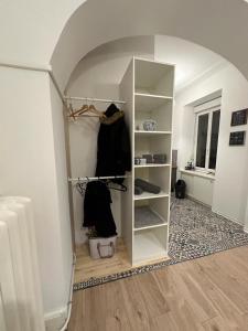 Cette chambre dispose d'une voûte et d'un placard avec des vêtements. dans l'établissement Le Petit Café - Centre ville, parking gratuit, à Mulhouse