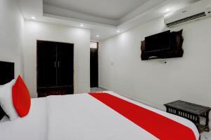 - une chambre avec un lit et une télévision murale dans l'établissement Flagship Ap Royal, à Indirapuram