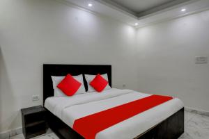 - une chambre avec un grand lit et des oreillers rouges dans l'établissement Flagship Ap Royal, à Indirapuram