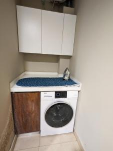 a washing machine in a kitchen with white cabinets at Goldcrest Mall One-bed Penthouse in Lahore