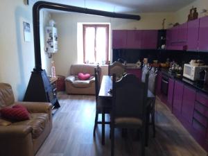 a kitchen with purple cabinets and a table and chairs at B&B La Stria del Re in Rino