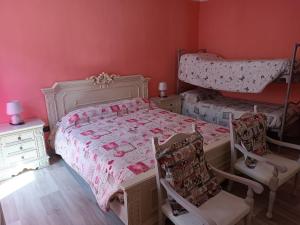 a bedroom with pink walls and a bed and two chairs at La Stria del Re in Rino