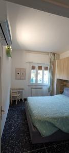 een slaapkamer met een bed, een tafel en 2 ramen bij Sonia's house in Albissola Marina