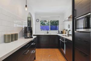 a kitchen with brown cabinets and a sink and a window at NORM3/17 - Little Hacienda in Perth