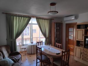 uma sala de estar com uma mesa e uma mesa e cadeiras em Luna Home em Villajoyosa