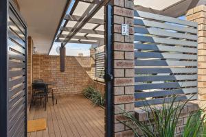 a patio with a blue railing on a brick wall at NORM3/17 - Little Hacienda in Perth +6 photos