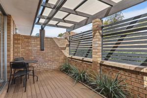 a patio with a table and chairs on a brick wall at NORM3/17 - Little Hacienda in Perth