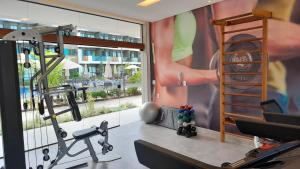 a fitness room with a gym with a large window at Flat Studio aconchegante com vista para piscina. in Ipojuca