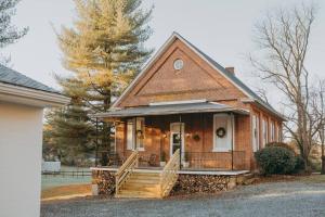 1900's Historic Lancaster School House في Willow Street: منزل من الطوب صغير مع شرفة