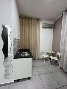 uma cozinha com um lavatório, uma mesa e cadeiras em bed & breakfast De Bono em Nápoles