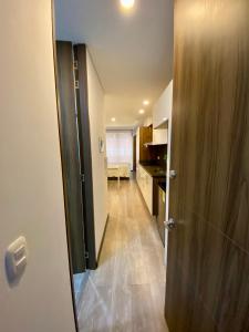 a hallway with a door leading to a kitchen and a room at Apartamento grande Soho 39 in Bogotá