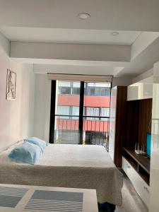 a bedroom with a large bed and a large window at Apartamento grande Soho 39 in Bogotá
