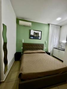 1 dormitorio con cama y pared verde en bed & breakfast De Bono en Nápoles