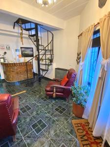 a living room with two chairs and a staircase at Hospedaje Los Nietos in El Calafate +13 photos