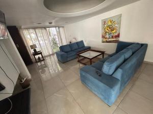 sala de estar con sofá azul y mesa en Casa Barrio Bombal en Mendoza