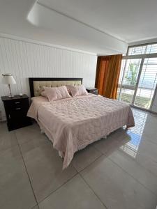 um quarto com uma cama grande e almofadas cor-de-rosa em Casa Barrio Bombal em Mendoza