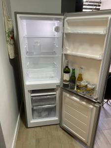 un frigorifero vuoto con la porta aperta e bevande all'interno di Departamento con piscina vista panorámica a Coquimbo