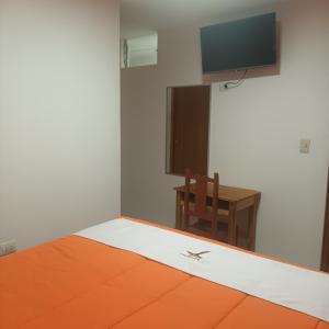 um quarto com uma cama, uma cadeira e uma televisão em VILLA MARAS Hotel em Maras