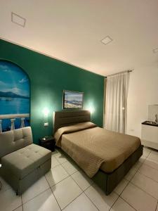 bed & breakfast De Bono في نابولي: غرفة نوم بحائط أخضر مع سرير وأريكة