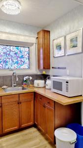 eine Küche mit einer Spüle und einer Mikrowelle auf der Theke in der Unterkunft Winnipeg Holiday in Winnipeg