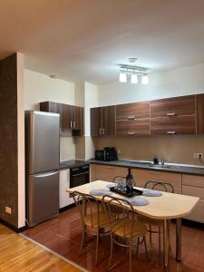 uma cozinha com uma mesa e cadeiras e um frigorífico em Apartament “La Iepure” em Brasov