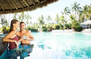 um homem e uma mulher numa piscina em Palm Bungalows em Hamilton Island