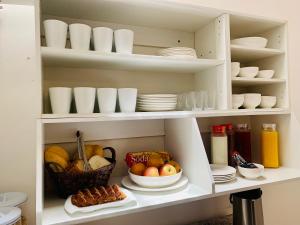 a cupboard filled with plates and bowls of fruit at Península Hostel & Coffee in Iquique