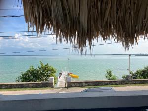 a dock in the middle of the water with a boat at Rum punch lodge in Corozal