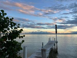 a dock on a body of water with a sunset at Rum punch lodge in Corozal