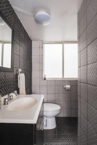 ein Bad mit einem Waschbecken, einem WC und einem Fenster in der Unterkunft nice apt. Roma CDMX :) in Mexiko-Stadt
