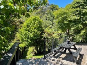 a wooden picnic table sitting on a deck at Huatoki Hideaway Peaceful Central Location in New Plymouth