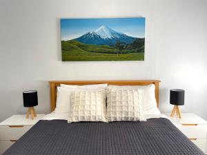 1 dormitorio con 1 cama con una foto de montaña en Huatoki Hideaway Peaceful Central Location, en New Plymouth