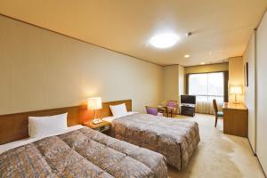 Habitación de hotel con 2 camas y escritorio en Suhaku, en Suwa